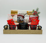 Gift basket with mugs, snacks, and a candle on a white background